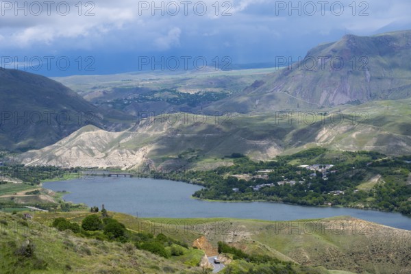 View of a lake nestled in mountainous landscape under cloudy sky, landscape with Shamb Reservoir near Ltsen, Vorotan River, Syunik Province, Syunik, Caucasus, Armenia