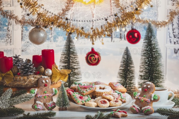 Christmas table with cookies, balls and decoration in front of snowy landscape