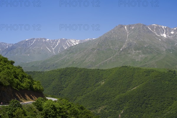 Green wooded hills and majestic mountains under clear blue sky, landscape on M2 near Meghri Pass, Tashtun Pass, Syunik Province, Syunik, Armenia