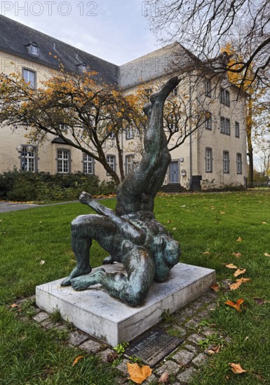 Sculpture entitled Wrestling Group by Jo Jastram in front of the former Kempen Franciscan monastery in autumn, Lower Rhine, Germany