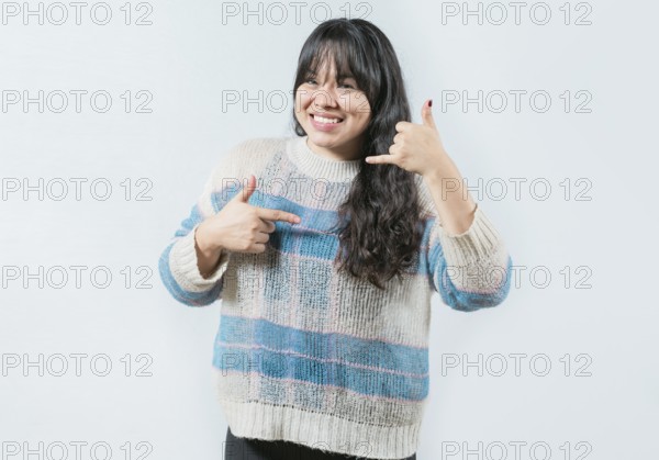 Cheerful asian woman gesturing CALL ME in sign language isolated. Beautiful girl making gesture CALLING in nonverbal language