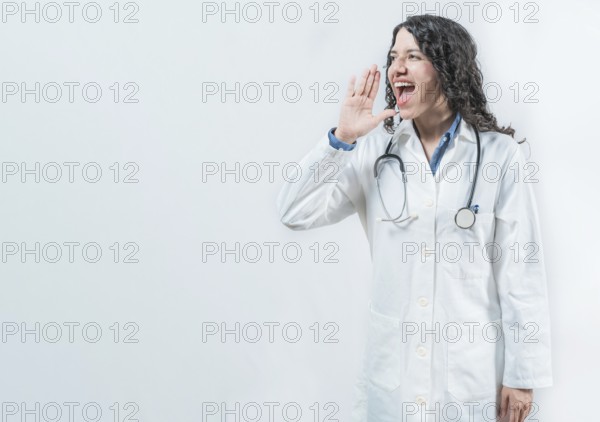 Female doctor shouting an announcement isolated. Young doctor shouting a promotion on isolated background