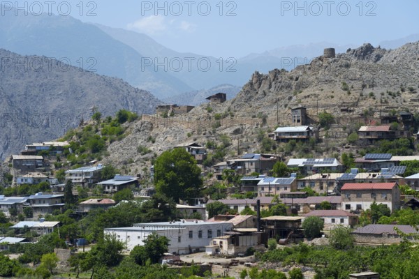 Hilly landscape with a village using solar panels, surrounded by rocky mountains in sunny weather, Meghri, Syunik province, Syunik, not far from the border with Iran, Armenia