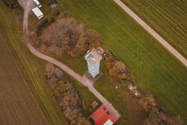 An observation tower in the middle of a rural landscape with fields and buildings, surrounded by autumn colors, Dürrenmettstetten observation tower, Germany