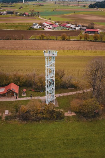 An observation tower in the middle of a rural landscape with fields and buildings, surrounded by autumn colors, Dürrenmettstetten observation tower, Germany