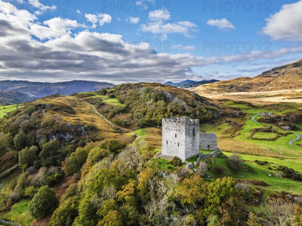 Autumn colours over Castell Dolwyddelan and Eryri Mountains from a drone, Snowdonia, Conwy County Borough, Wales, England, United Kingdom
