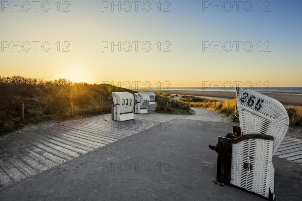 Beach chairs in the dunes and blue sky in winter, sunset, Spiekeroog, East Frisian Islands, Lower Saxony, Germany