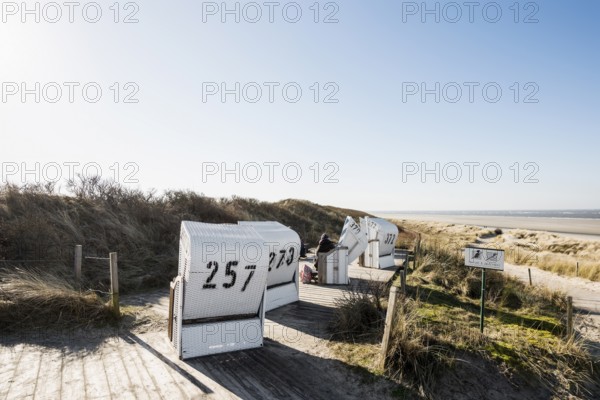 Beach chairs in the dunes and blue sky in winter, Spiekeroog, East Frisian Islands, Lower Saxony, Germany