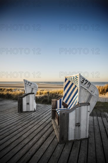 Beach chairs in the dunes and blue sky in winter, sunset, Spiekeroog, East Frisian Islands, Lower Saxony, Germany