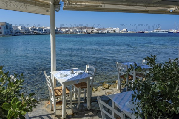 Mykonos, Cyclades, Greece - Small picturesque tavern right on the waterfront, on the harbor in the old town of Mykonos Town, Mykonos Chora. Mykonos is part of the Cyclades archipelago