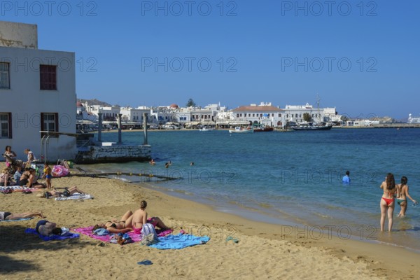 Mykonos, Cyclades, Greece - Tourists and locals like to bathe on the small town beach Paralia Chora Mikonou right at the harbor in the old town of Mykonos Town, Mykonos Chora. Mykonos is part of the Cyclades archipelago