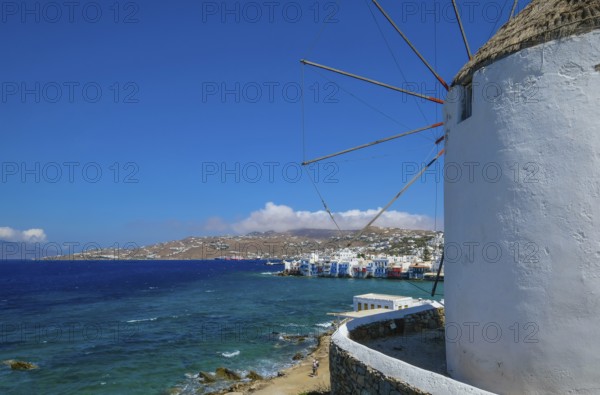 Mykonos, Cyclades, Greece - The six sixteenth-century windmills, lined up on a hill above Mykonos Town, Mykonos Chora, are the island's landmark. At the back, right by the sea, are the colorful houses of Little Venice. Mykonos is part of the Cyclades archipelago in the Aegean Sea