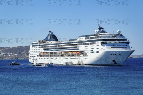 Mykonos, Cyclades, Greece - Cruise ship MSC Lirica is located in Mykonos Harbour Bay. Cruise ships bring tourists to shore