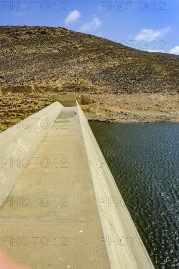 Mykonos, Cyclades, Greece - Dry Fokos Reservoir near Ano Mera. The Mykonos Municipal Water Supply and Sewage Management Company has two dams, Marathi Reservoir and Fokos Reservoir, to supply water to the island. Due to the prolonged drought, both are almost empty and are not being used
