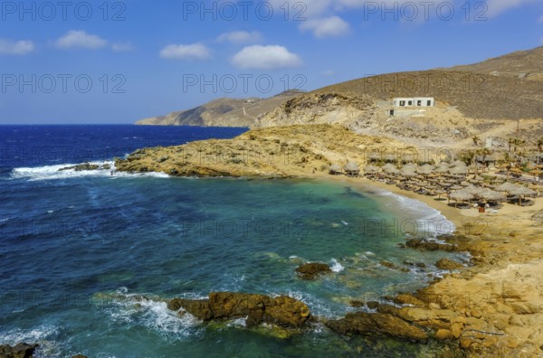 Mykonos, Cyclades, Greece - Ftelia Beach, Ftelia Beach, sandy beach on a windy rocky coast in the north of the island. On the right, an expensive luxury beach club, Alemagou restaurant