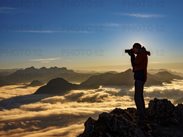 Photographer in evening light at the summit, view of an alpine panorama, Hochstaufen, Chiemgau Alps, Upper Bavaria, Bavaria, Germany