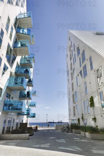 Distinctive white residential complex, turquoise balconies against blue sky, pyramid-shaped buildings, Isbjerget, iceberg, modern architecture in the harbor, Aarhus, Jutland, Denmark