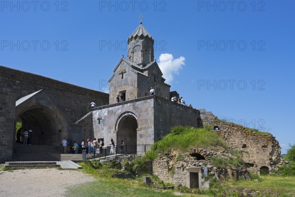 Historic stone church with ruins and grassy areas under clear blue sky, Tatev monastery, Armenian Apostolic monastery, Syunik province, Syunik, Caucasus, Armenia