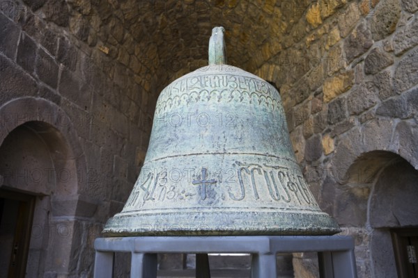 Ancient bell with engraved inscription in stone arch, church bell, Tatev monastery, Tatev, Armenian Apostolic monastery, Syunik province, Caucasus, Armenia
