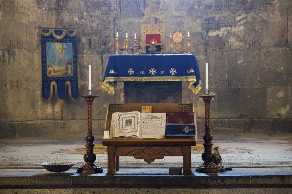 Religious altar in a church with decorated candelabra, lit candles and an opened book, Tatev monastery, Armenian Apostolic monastery, Syunik province, Caucasus, Armenia