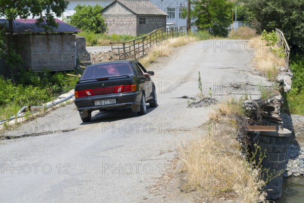 A black car crosses a dilapidated bridge in rural area, Lada Samara drives on bridge over the Debed River, Ayrum, Tavush province, Tavush, Armenia