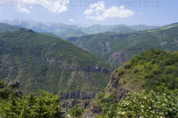 Green mountains under clear sky with white clouds, idyllic and peaceful atmosphere, view from the Halidzor observation deck towards the monastery, Tatev, Syunik province, Syunik, Armenia