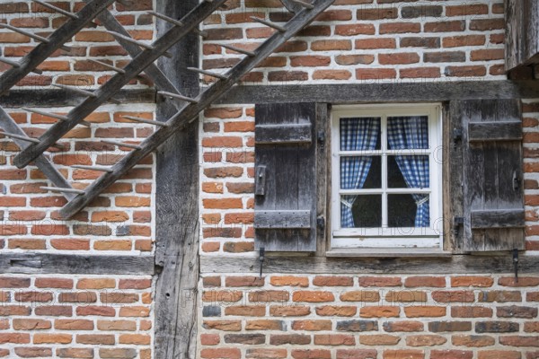 A rustic half-timbered house with red brick and wooden shutters, Münsterland, North Rhine-Westphalia, Germany