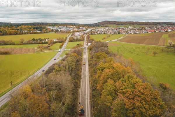 Wide landscape with roads, autumn fields and a village in the background under overcast sky, construction of the Hermann Hesse Railway, Im Hau, Calw, Germany