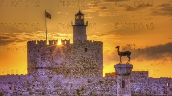 Agios Nikolaos fortress, castle with lighthouse and statue in rising sun and golden sky, UNESCO World Heritage Site, Old Town of Rhodes Town, Rhodes, Dodecanese, Greece