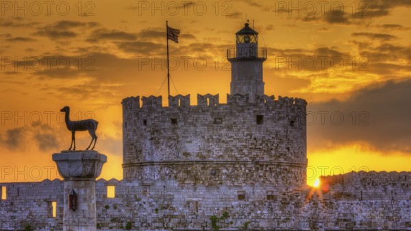 Agios Nikolaos fortress, historic castle with statue in front of a warm sunrise sky, UNESCO World Heritage Site, Old Town of Rhodes Town, Rhodes, Dodecanese, Greece