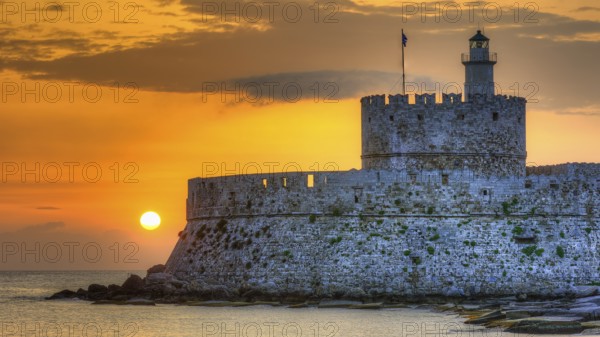Agios Nikolaos fortress, castle with lighthouse in the golden hour at sunrise and peaceful sea in the background, UNESCO World Heritage Site, Old Town of Rhodes Town, Rhodes, Dodecanese, Greece
