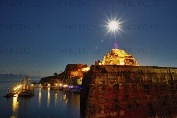 Old fortress, illuminated fortress at night with cross and starry sky over quiet harbor, UNESCO World Heritage Site, Old Town of Corfu, Corfu, Corfu, Ionian Islands, Greece