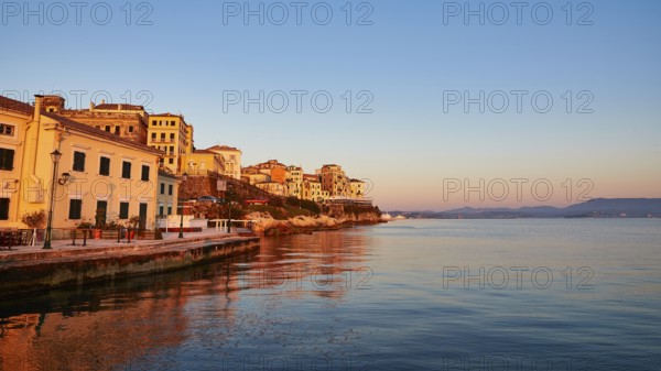 Picturesque coastal town at sunrise with reflection in water, UNESCO World Heritage Site, Old Town of Corfu, Corfu, Kerkyra, Ionian Islands, Greece