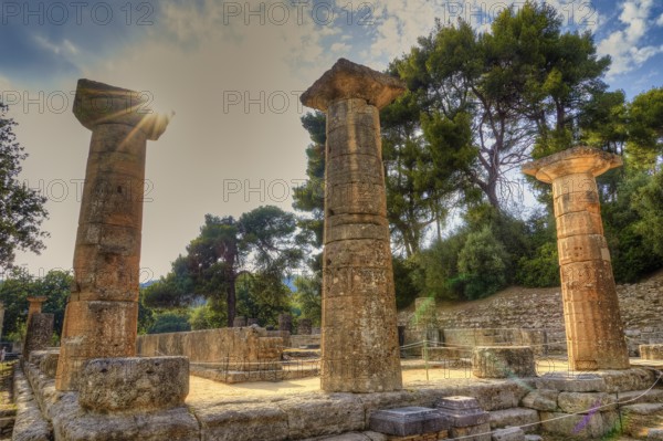 Temple of Hera, ancient Greek ruins with columns, illuminated by sunbeams, surrounded by trees, UNESCO World Heritage Site, Ancient Olympia, Peloponnese, Greece