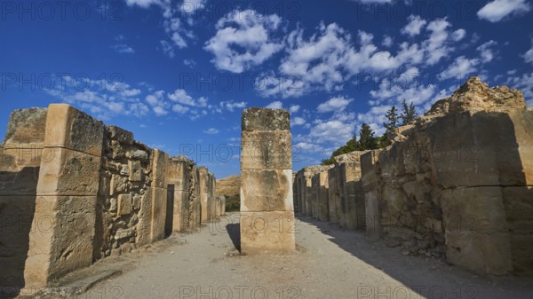 Old ruins with high stone walls under blue sky with scattered clouds, UNESCO World Heritage Site, Minoan Palace of Festos, Crete, Greece
