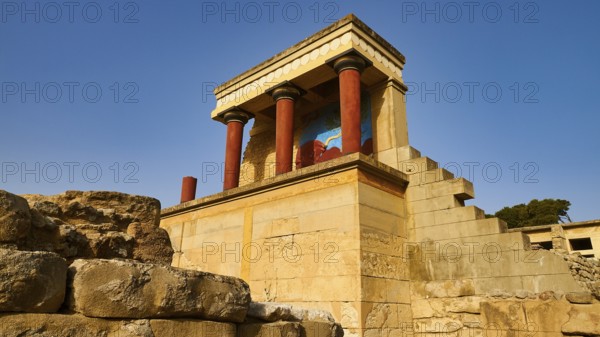 Ancient ruins with typical red Minoan columns and wall painting, under blue sky on the island of Crete, UNESCO World Heritage Site, Minoan Palace of Knossos, Crete, Greece
