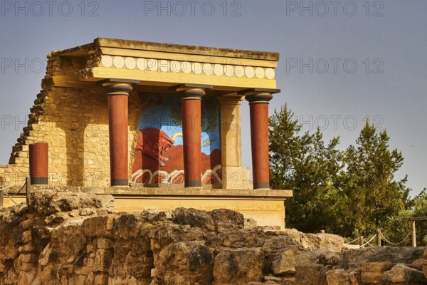 Part of the ancient palace of Knossos with well-preserved fresco and red columns surrounded by trees, UNESCO World Heritage Site, Minoan Palace of Knossos, Crete, Greece