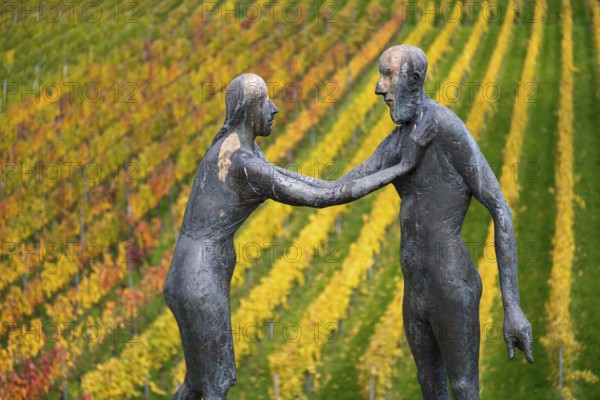 Sculpture of two people in front of colorful vines in autumn, emphasized by artistic expressiveness, sculpture trail near Strümpfelbach im Remstal, Baden-Württemberg, Germany