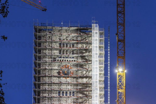 Bonatz building with station tower. Construction work for Stuttgart 21 at the main train station in the evening. A construction worker on the scaffolding in front of the station clock. Stuttgart, Baden-Württemberg, Germany