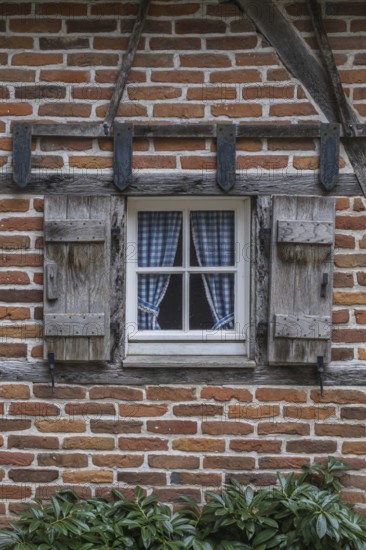 Rustic window with blue curtains and wooden shutters on the brick wall, Münsterland, North Rhine-Westphalia, Germany