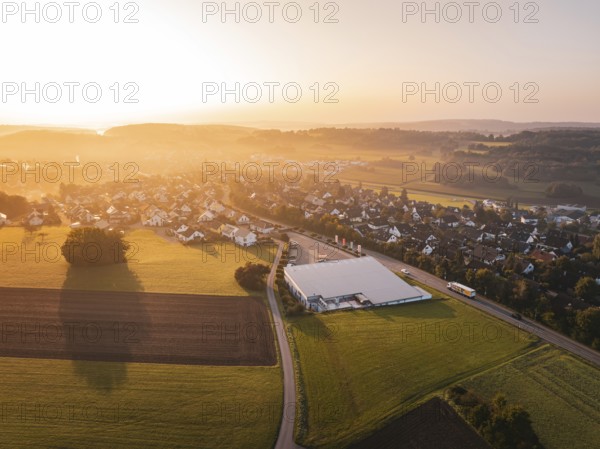 Aerial view of village with fields and sunset in the background, Gechingen, Germany