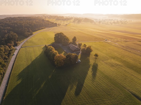 Rural area with farmhouse and fields in the evening sun from the air, Gechingen, Germany