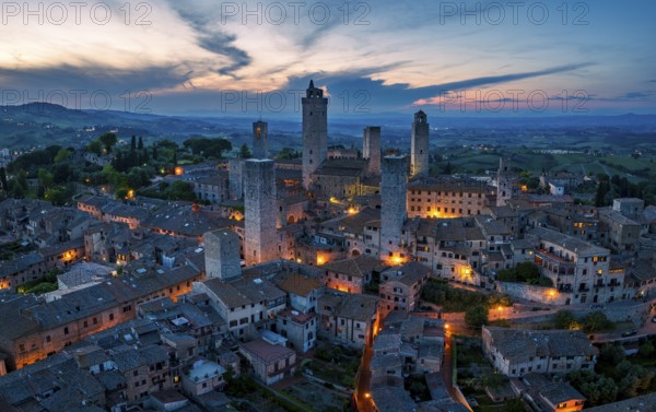 City view of San Gimignano at dusk, gender towers and medieval buildings, Tuscany, Italy