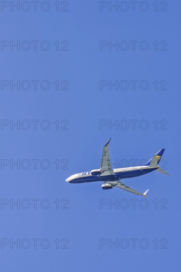 Ryanair passenger plane flying on a clear blue sky, Mallorca, Spain