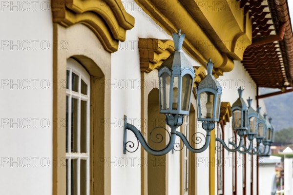 Antique metal lanterns decorating the facade of a historic colonial-style house in the city of Ouro Preto, Ouro Preto, Minas Gerais, Brazil