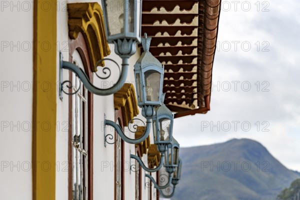 Several antique metal lanterns decorating the historical facade of a colonial-style house in the city of Ouro Preto, Ouro Preto, Minas Gerais, Brazil