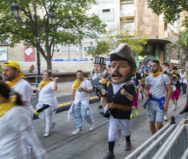 Evening procession through city streets by youth group organisation, Pilar 2025 festival event, Zaragoza, Aragon, Spain