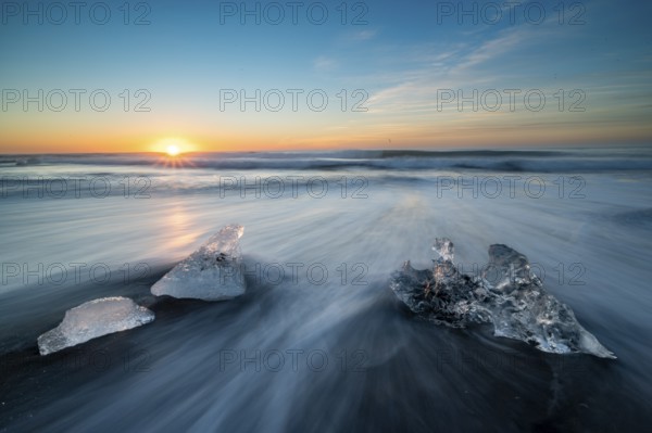 Beach with waves, ice formations, rising sun, Diamont Beach, Jökulsarlon, Iceland