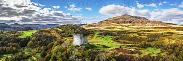 Autumn colours over Castell Dolwyddelan and Eryri Mountains from a drone, Snowdonia, Conwy County Borough, Wales, England, United Kingdom