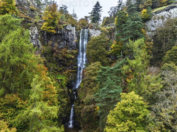 Autumn colours over Pistyll Rhaeadr Waterfall and Berwyn Mountains from a drone, Oswestry, Shrewsbury, Wales, England, United Kingdom